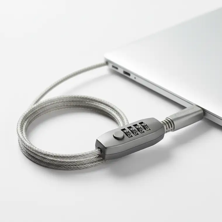 Pracownik w biurze coworkingowym zabezpiecza laptopa firmowego linką i szyfrowaniem dysku, aby chronić go przed kradzieżą w otwartym biurze